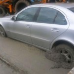 Mulher interrompe trânsito por várias horas. Estacionou um Mercedes em cima de cimento fresco!